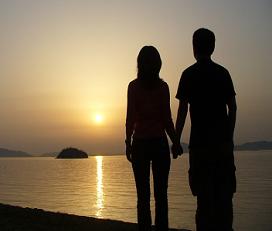 lovers holding hands at sunset on beach