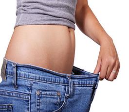 Woman showing weight loss in loose fitting jeans